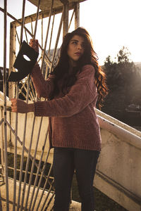 Portrait of woman standing by railing