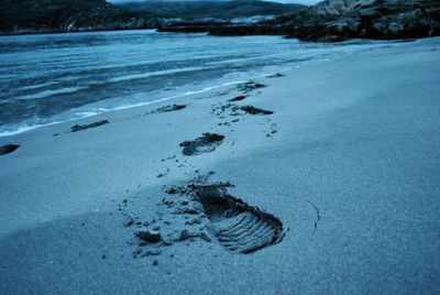 Close-up of footprints on frozen beach