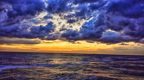 Scenic view of sea against dramatic sky during sunset