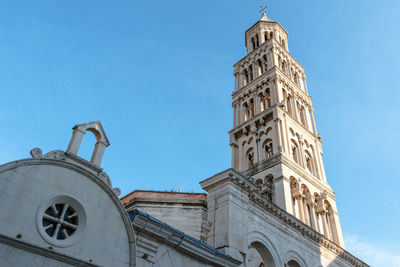 Low angle view of bell tower against blue sky