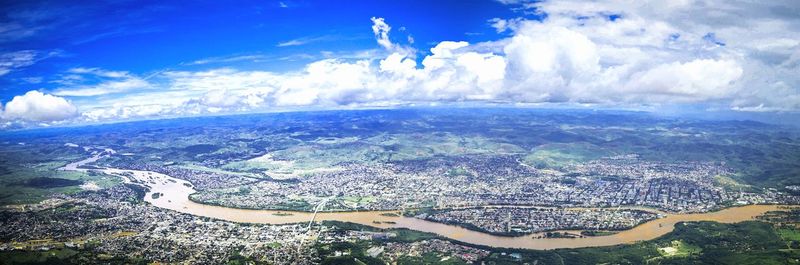 Aerial view of city by sea against sky