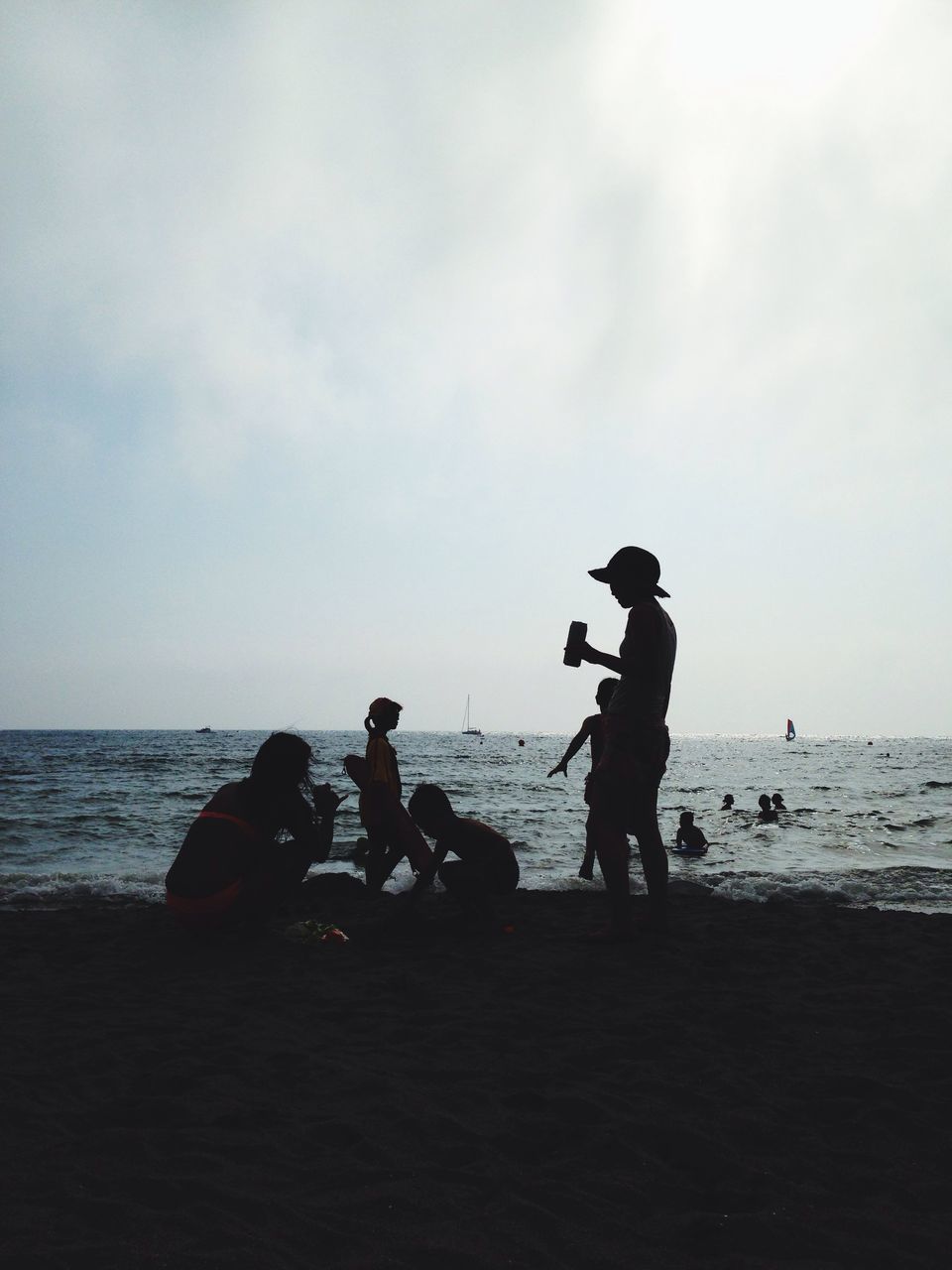 sea, water, leisure activity, lifestyles, horizon over water, sky, men, beach, togetherness, boys, full length, childhood, shore, bonding, vacations, transportation, silhouette, nature