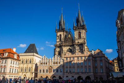 Group of people in front of building against blue sky