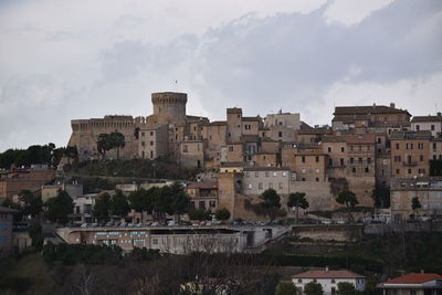 Buildings in city against cloudy sky