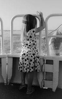Girl standing at boat deck against sea
