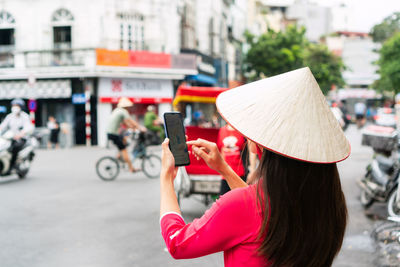 Young woman using mobile phone in city