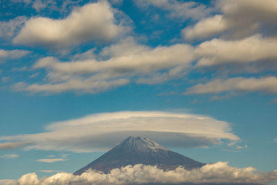 Aerial view of snowcapped mountain against cloudy sky