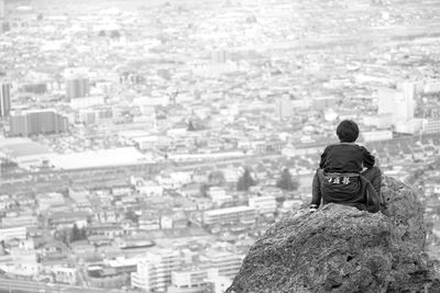 Rear view of man with cityscape in background