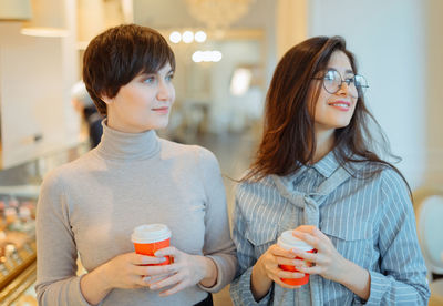 Beautiful women holding coffee cup at store