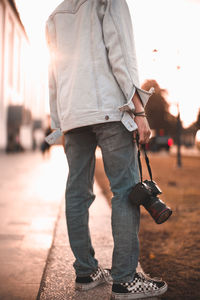 Rear view of man with umbrella standing on street