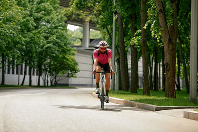 Rear view of man riding bicycle on road