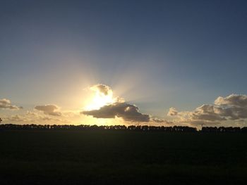 Silhouette field against sky during sunset