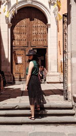 Full length of woman standing at entrance of building