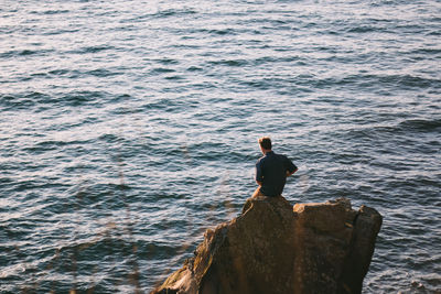 High angle view of man on rock against sea