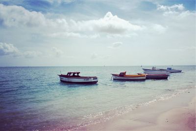 Boats moored on sea against sky