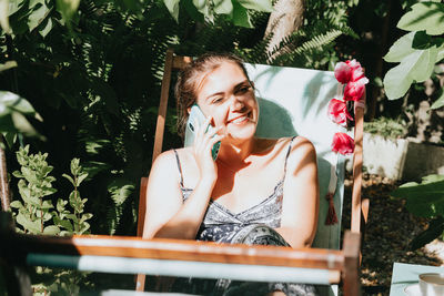 Woman talking on smart phone while sitting outdoors