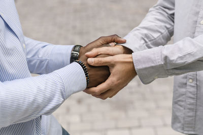 Midsection of couple holding hands