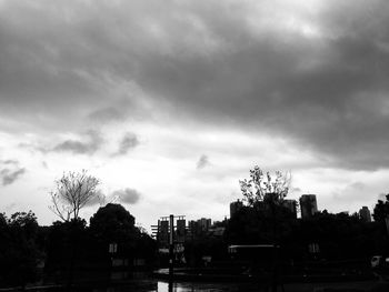 Silhouette trees and buildings against sky