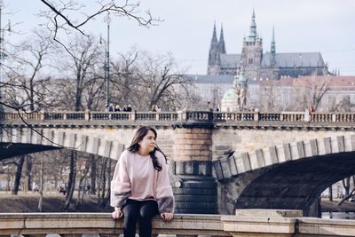 Full length of woman standing on bridge in city