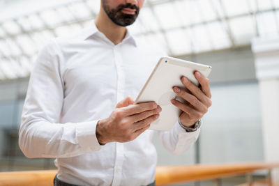 Midsection of businessman using digital tablet