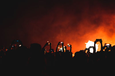 Silhouette people photographing at music concert