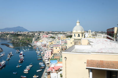 Aerial view of town by buildings against clear sky of procida