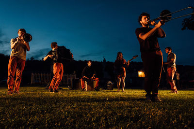 People playing on field against sky