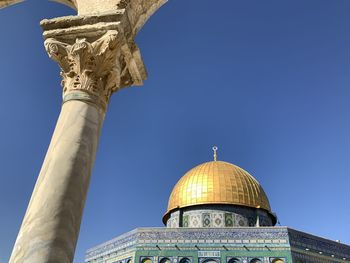 Low angle view of bell tower against blue sky