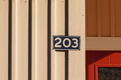 Number 203 on a sign and wood on which the spring light falls differently