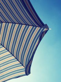 Low angle view of umbrella against clear blue sky