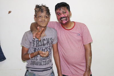 Portrait of friends standing against white background