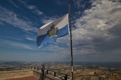 Low angle view of flag on built structure against sky