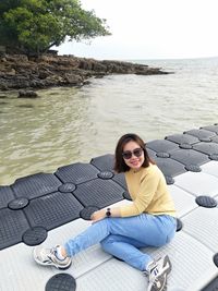 Portrait of woman sitting on sea shore