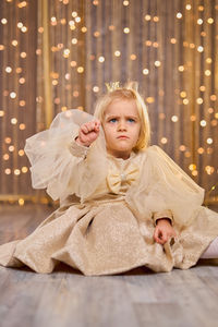 Portrait of smiling young woman standing against wall