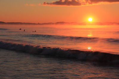 Scenic view of sea against orange sky