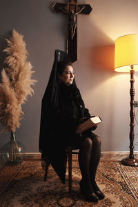 Young woman sitting on chair at home