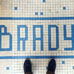 Low section of man standing on tiled floor