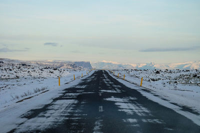 Scenic view of road through landscape during winter