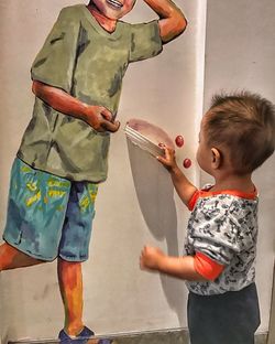 Side view of friends standing against wall