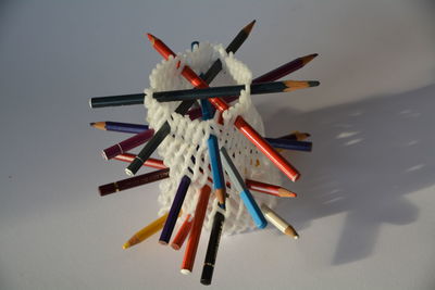 High angle view of pencils in fabric against white background