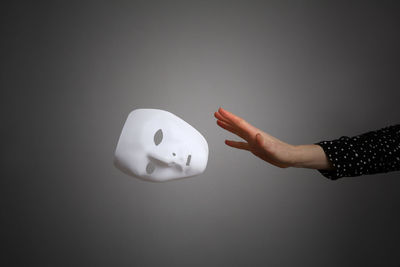 Midsection of person holding paper over white background