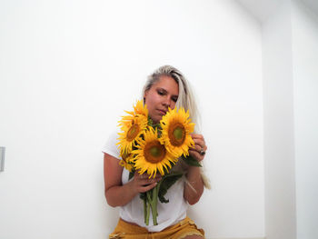 Portrait of woman holding yellow flower