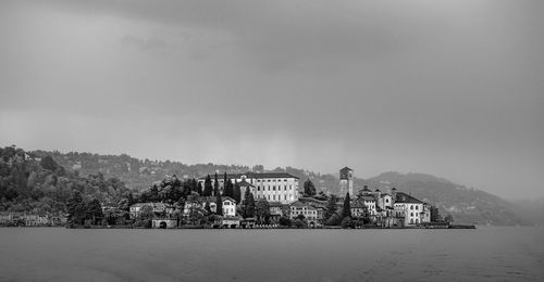 Buildings by sea against sky in city