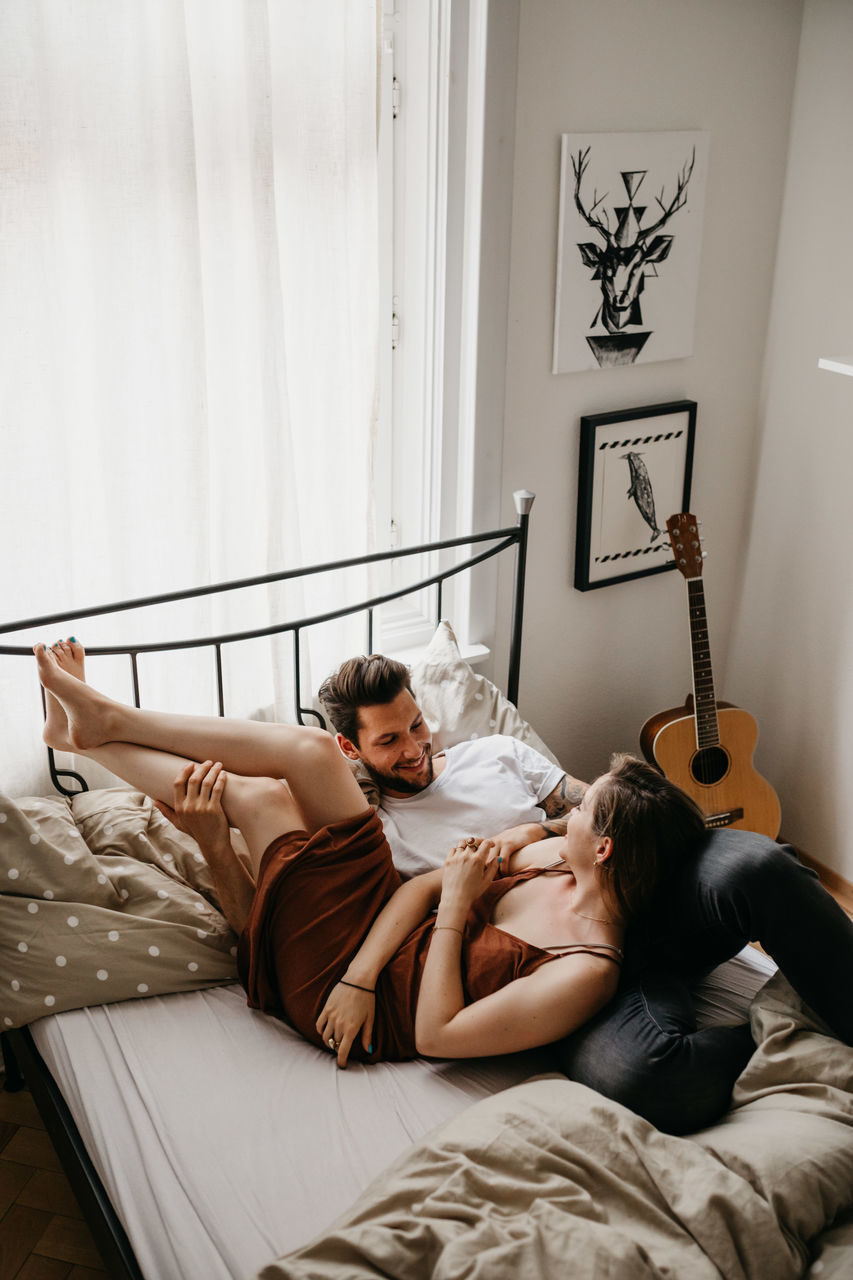 YOUNG COUPLE LYING ON BED