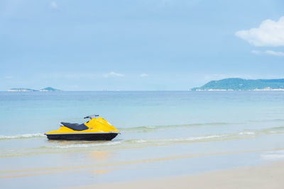 Boat on sea shore against sky