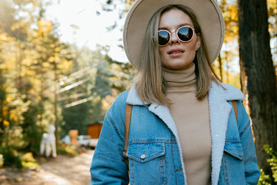 Portrait of woman wearing sunglasses standing against plants