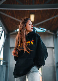 Beautiful young woman looking away while standing in outdoors