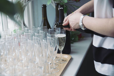 Close-up of woman pouring glass on table