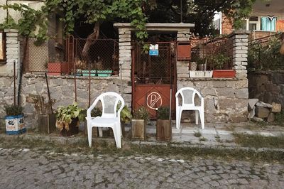 View of chairs outside house against trees