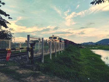 Panoramic view of train against sky during sunset